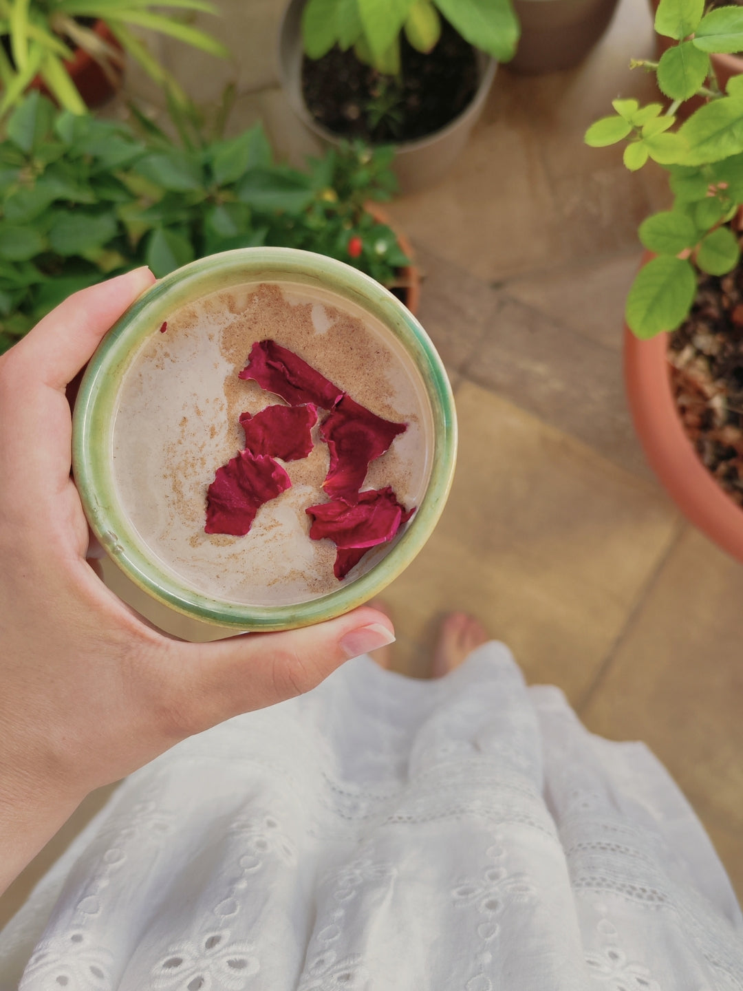 Manos sosteniendo taza de cacao ceremonial como ritual de equilibrio y cuidado físico y emocional