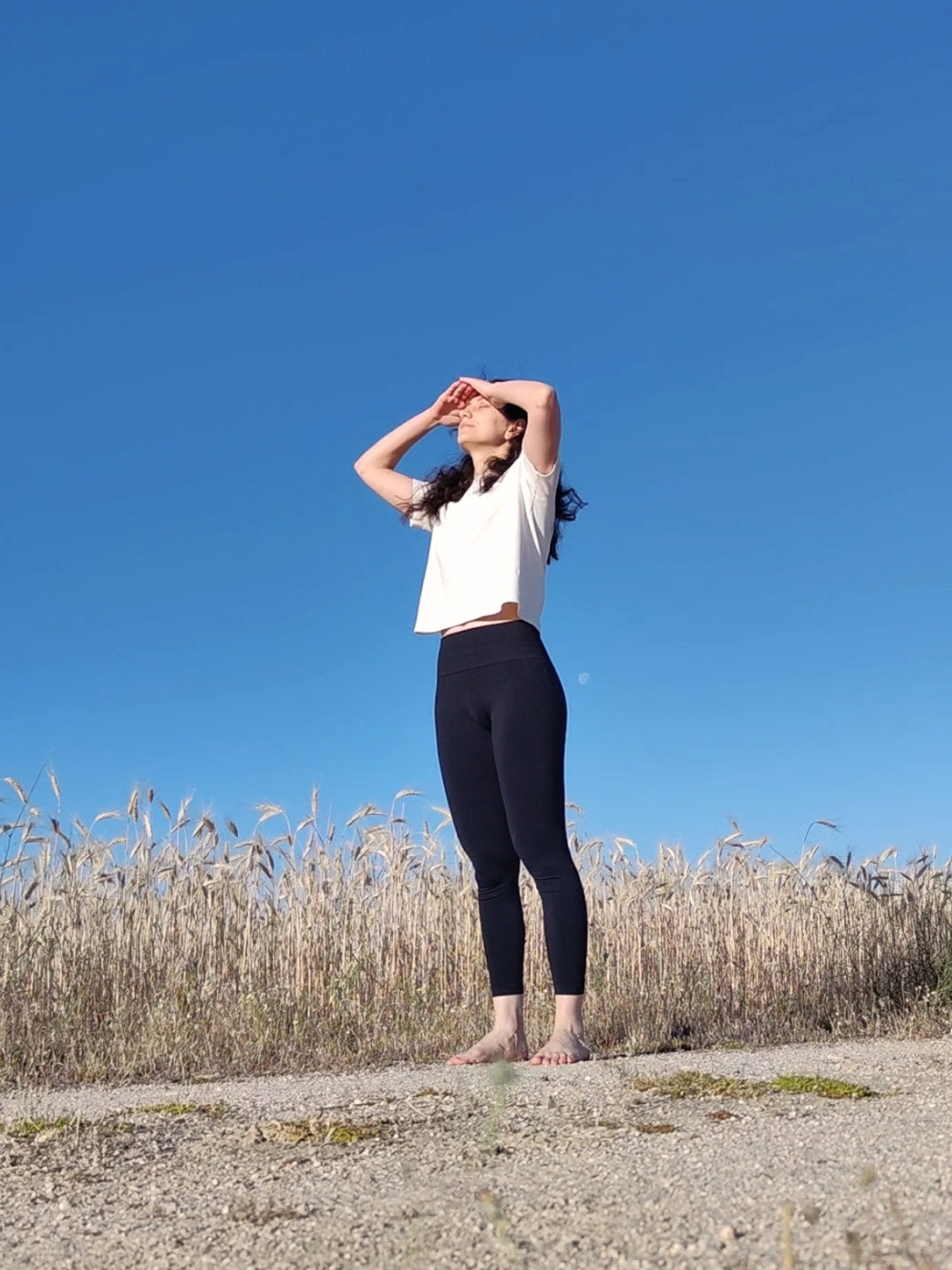 Mujer en la naturaleza con los brazos abiertos practicando mindfulness